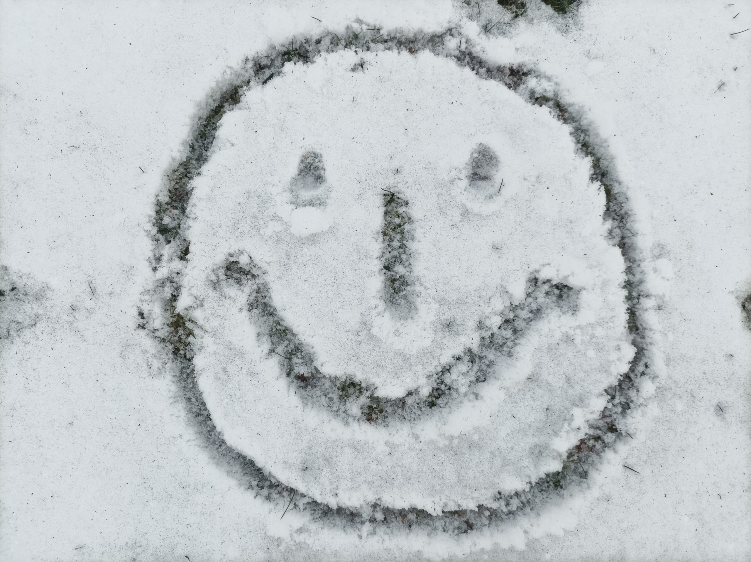 Ein Smiley in den Schnee gezeichnet, Lächeln, begegnen