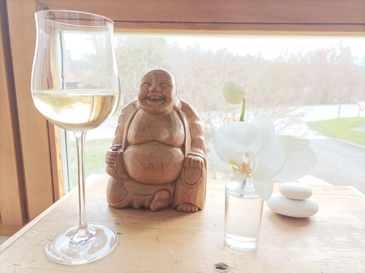 Soulandlove Blog Buddha Skulptur neben einem Glas Wein am Fenster